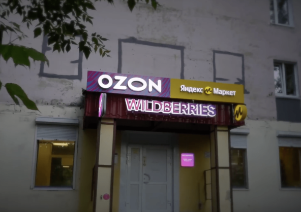 Вход в точку: вывески Ozon, Яндекс Маркета и Wildberries над одной дверью